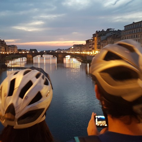people admiring sunset from a bridge in florence