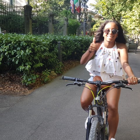 girl posing for the picture while she rides the bike