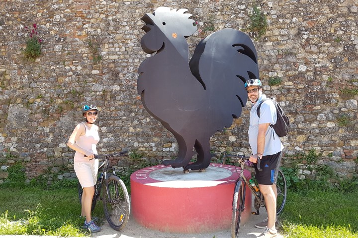 couple near a rooster sculpture in chianti
