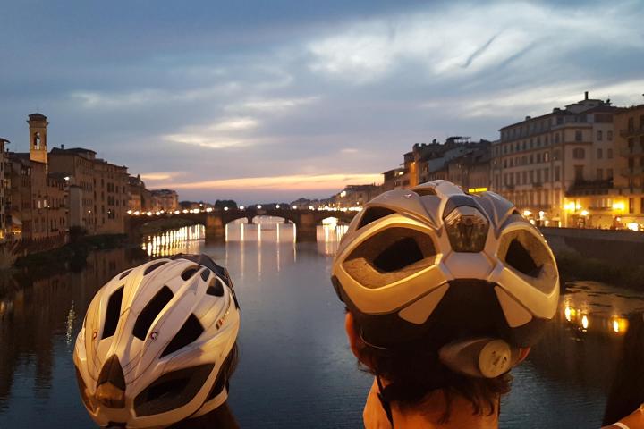 people with helmets watching sunset in Florence